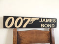 Wooden sign with '007 James Bond' text on a white background